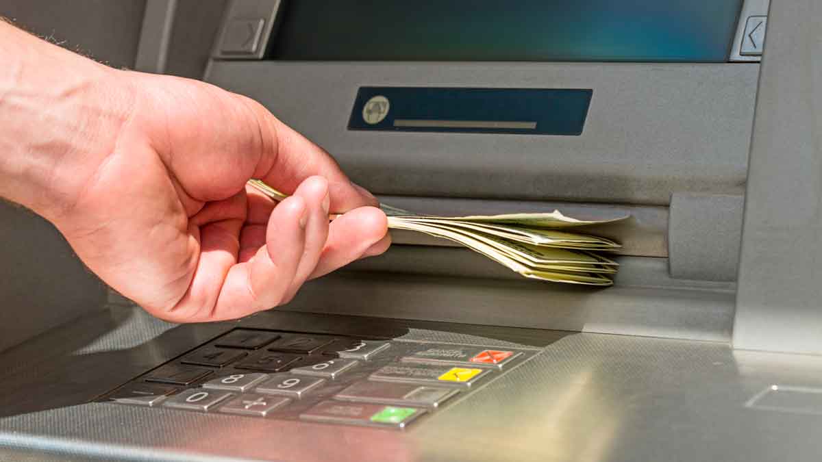 Mano retirando efectivo de un cajero automático; la nueva ley de accesibilidad exige interfaces inclusivas desde el 28 de junio en España.