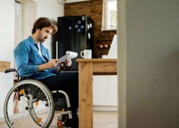 Hombre en silla de ruedas revisa documentos tras la sentencia del Supremo que prohíbe compatibilizar la pensión de incapacidad permanente absoluta con un trabajo cotizado.
