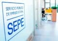 Logotipo del SEPE en una oficina moderna donde se tramitan subsidios y se vigila el cumplimiento de los requisitos de carencia de rentas