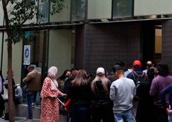 Cola de solicitantes ante una oficina de extranjería en España tras la subida de tasas 2025