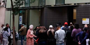 Cola de solicitantes ante una oficina de extranjería en España tras la subida de tasas 2025