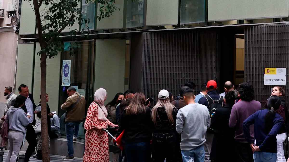 Cola de solicitantes ante una oficina de extranjería en España tras la subida de tasas 2025