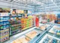 Pasillo de supermercado español repleto de productos y cámaras de congelados, antes de la liquidación total por cierre masivo