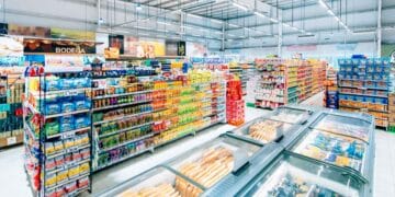 Pasillo de supermercado español repleto de productos y cámaras de congelados, antes de la liquidación total por cierre masivo