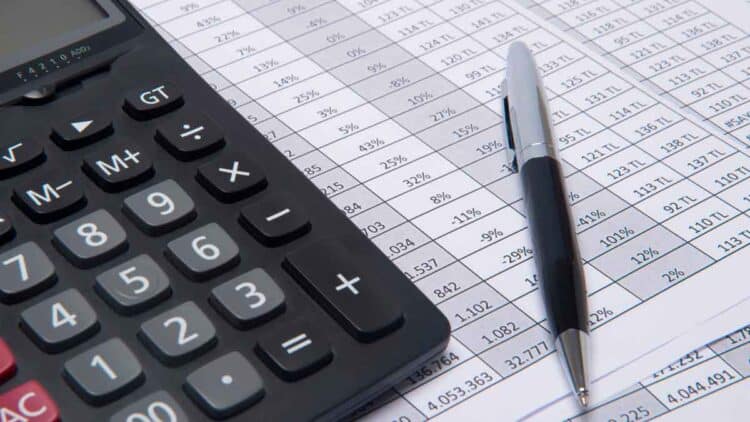 Calculadora y bolígrafo sobre hojas de nómina, ilustrando el descuento de cobros indebidos avalado por el Tribunal Supremo