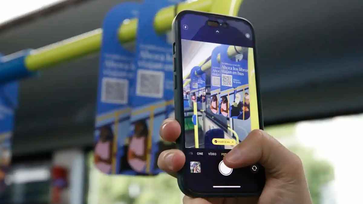 Pasajero escanea el código QR en un autobús EMT de Madrid para descargar libros digitales gratis con ‘Tu biblioteca a un clic’