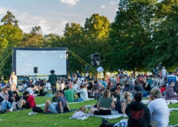Muchas personas esperando para ver una película al aire libre.