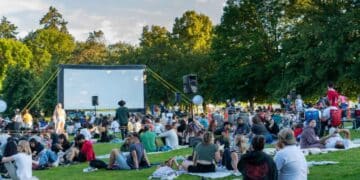 Muchas personas esperando para ver una película al aire libre.