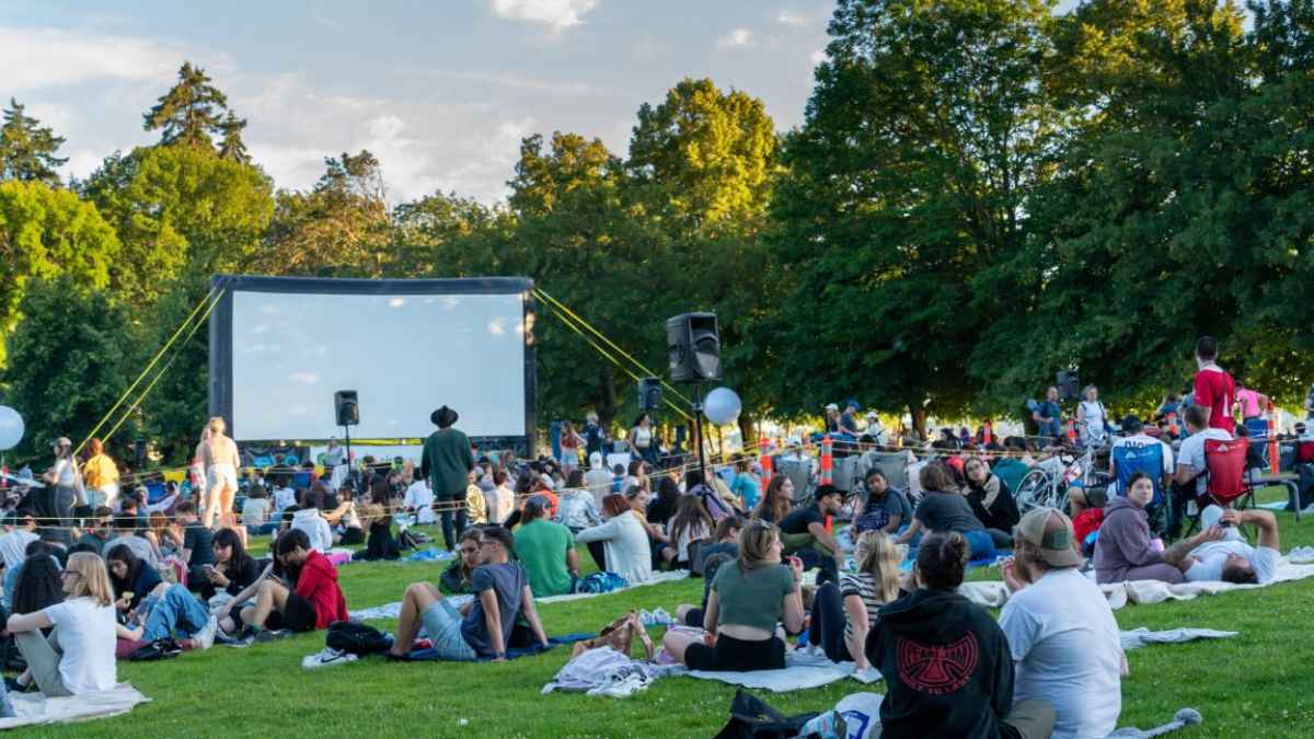 Muchas personas esperando para ver una película al aire libre.