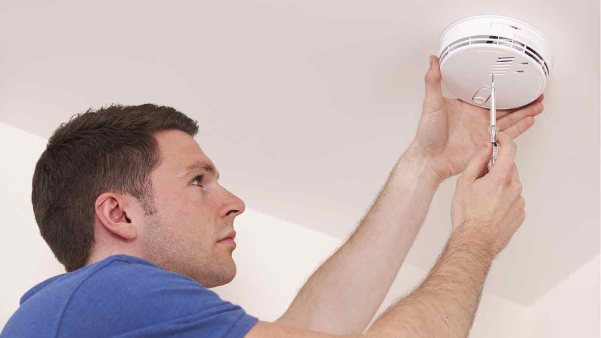 Instalación de detector de humo en vivienda madrileña para prevenir incendios.