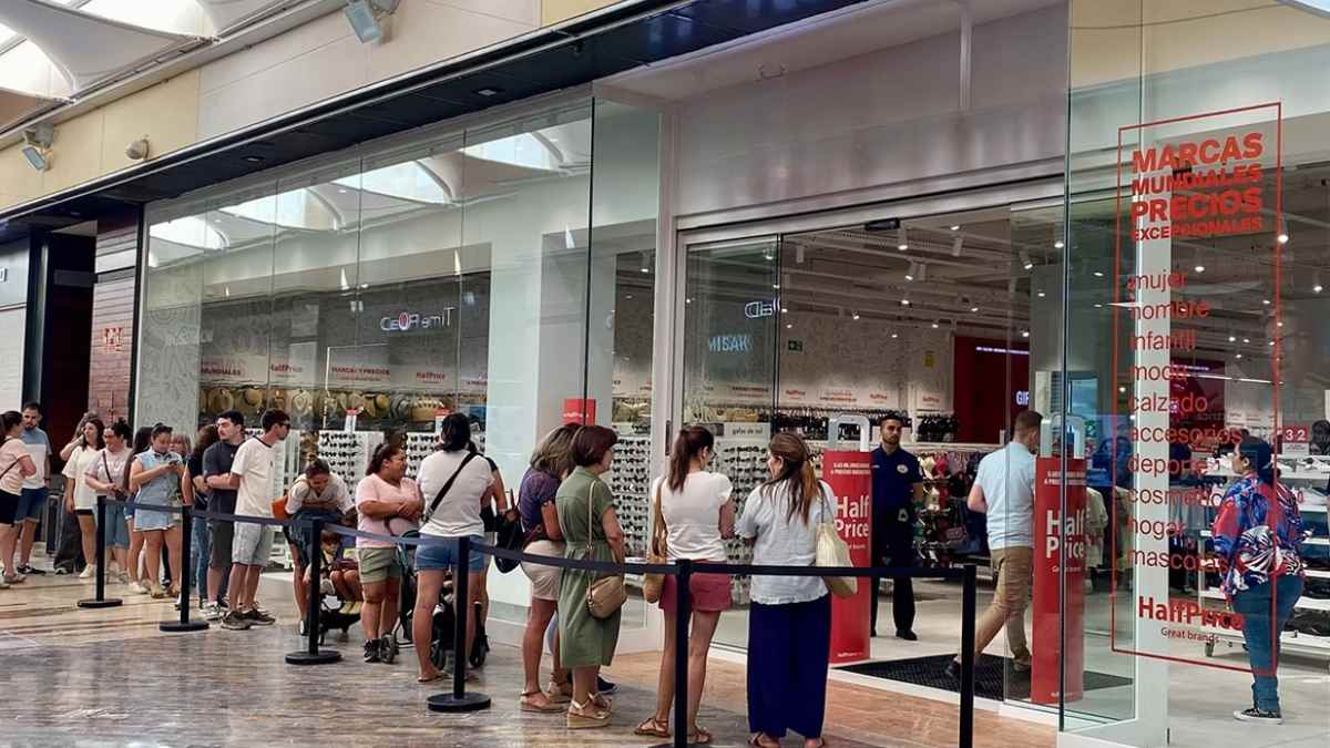 Clientes haciendo cola en HalfPrice Oasiz Madrid por la promoción 3x2 en marcas de lujo, julio 2025.