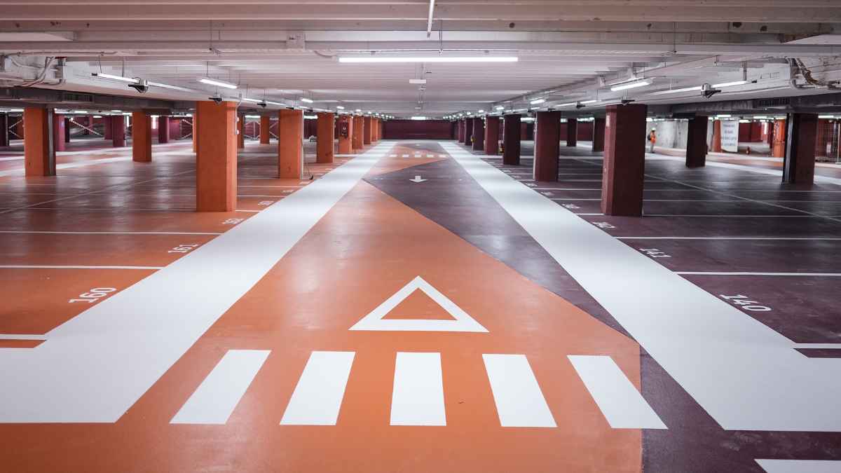 Interior del aparcamiento subterráneo de Plaza España, preparado con espacios para coches eléctricos y señalización moderna.
