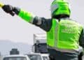 Agente de la Guardia Civil de Tráfico señalizando con banderín amarillo en carretera.