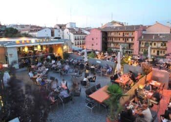 Terraza de un café en Lavapiés, Madrid, con clientes disfrutando de una noche de ocio en la zona de moda.
