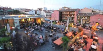 Terraza de un café en Lavapiés, Madrid, con clientes disfrutando de una noche de ocio en la zona de moda.