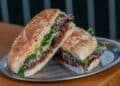 Bocadillo de carne con rúcula y pan crujiente servido en Chez Pepito en Chamberí