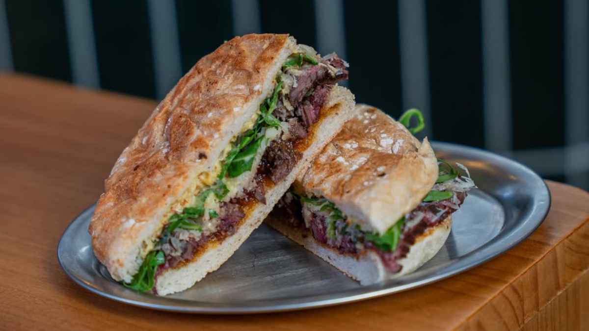 Bocadillo de carne con rúcula y pan crujiente servido en Chez Pepito en Chamberí