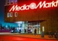 Fachada de MediaMarkt iluminada de noche durante los chollos nocturnos de televisores y móviles