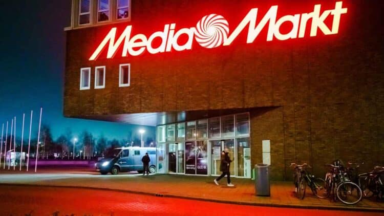 Fachada de MediaMarkt iluminada de noche durante los chollos nocturnos de televisores y móviles