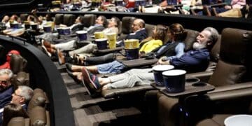 Personas mayores disfrutando de una película en un cine cómodo y con aire acondicionado en Madrid durante el verano.