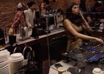 DJ pinchando en una coffee party en Madrid, con café de especialidad y público en una fiesta matinal saludable sin alcohol.