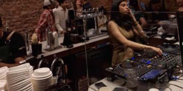 DJ pinchando en una coffee party en Madrid, con café de especialidad y público en una fiesta matinal saludable sin alcohol.
