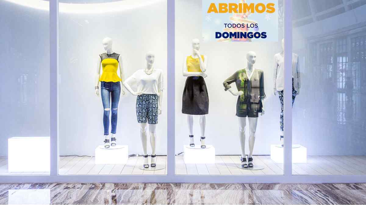 Escaparate de tienda abierta en domingo con cartel “Abrimos todos los domingos”, ejemplo de compensación por trabajar en festivo.