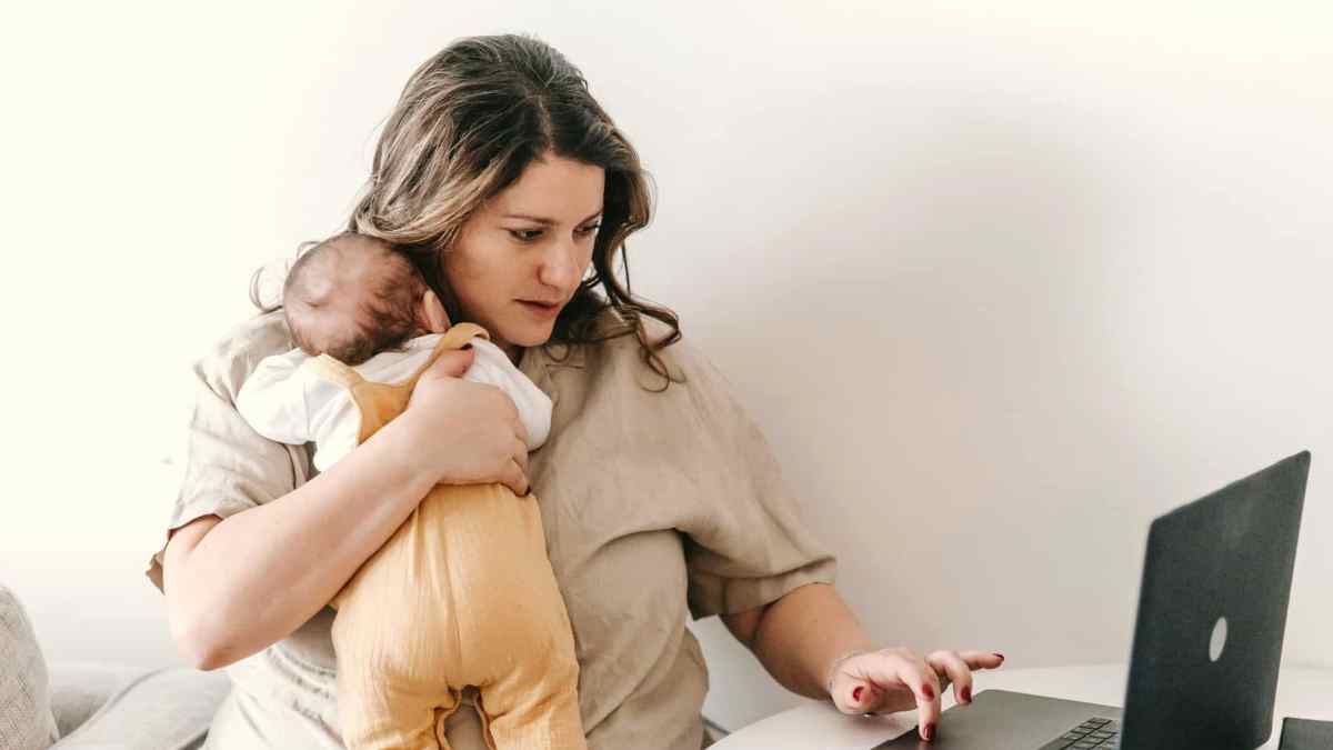 Madre con bebé solicita el complemento de brecha de género 2025 en su portátil tras la sentencia del Supremo.