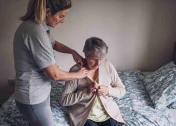 Asistente personal ayudando a persona mayor con dependencia en su hogar