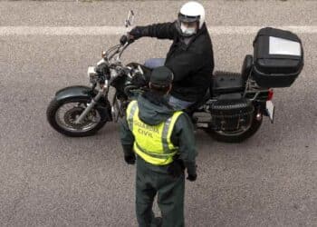Guardia Civil controla a un motorista en un tramo de carretera en obras.