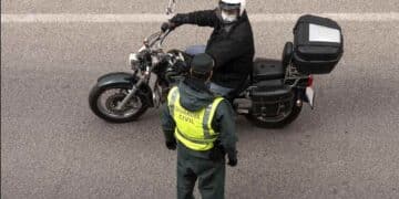 Guardia Civil controla a un motorista en un tramo de carretera en obras.