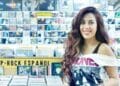 Interior de Discos La Metralleta en Madrid con mujer sonriendo junto a estanterías de vinilos y CD de pop-rock español.