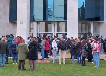 Candidatos haciendo cola frente a una sede de oposiciones para la Función Pública.