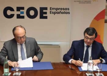 Empresarios firmando acuerdo en CEOE sobre indemnizaciones por despido tras decisión del Supremo.