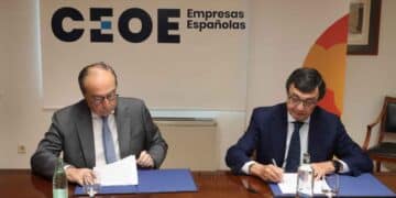 Empresarios firmando acuerdo en CEOE sobre indemnizaciones por despido tras decisión del Supremo.