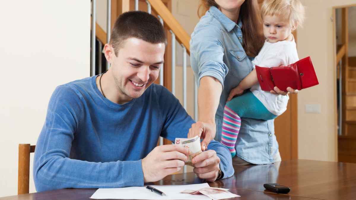 Padre contando dinero junto a madre con bebé, familias que obtienen hasta 1.462 € de ayuda económica del Ingreso Mínimo Vital.