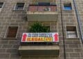 Cartel que indica que un piso turístico es ilegal en un edificio, con flechas y texto que señala la infracción.