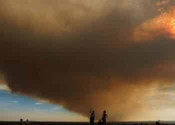 Columna de humo del incendio de Méntrida cubre la A-5 mientras varias personas observan el avance del fuego y la ceniza.
