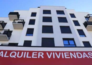 Edificio de viviendas en alquiler en Madrid con cartel rojo.