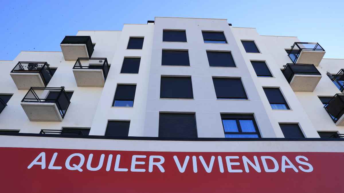 Edificio de viviendas en alquiler en Madrid con cartel rojo.