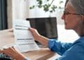 Mujer revisando documentos sobre los nuevos requisitos para jubilarse con pensión completa a los 63 años desde enero.
