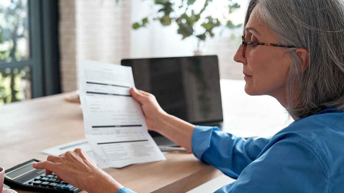 Mujer revisando documentos sobre los nuevos requisitos para jubilarse con pensión completa a los 63 años desde enero.