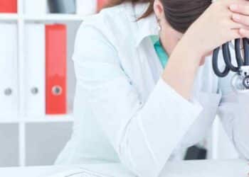 Médica agotada con estetoscopio simboliza síndrome de burnout reconocido y la indemnización de 17.000 € en Canarias.