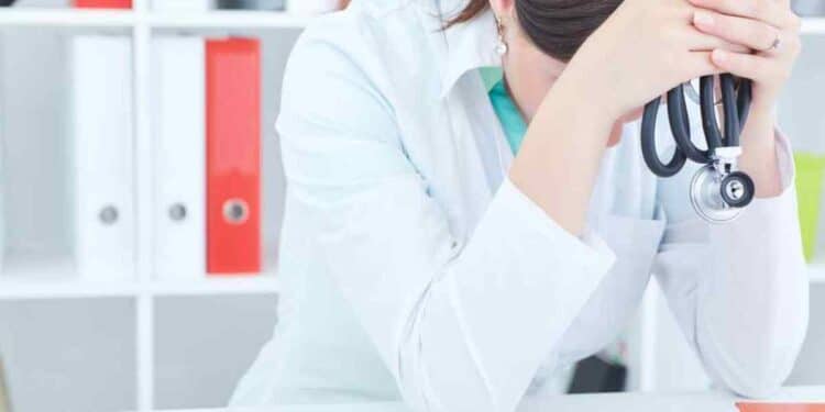Médica agotada con estetoscopio simboliza síndrome de burnout reconocido y la indemnización de 17.000 € en Canarias.