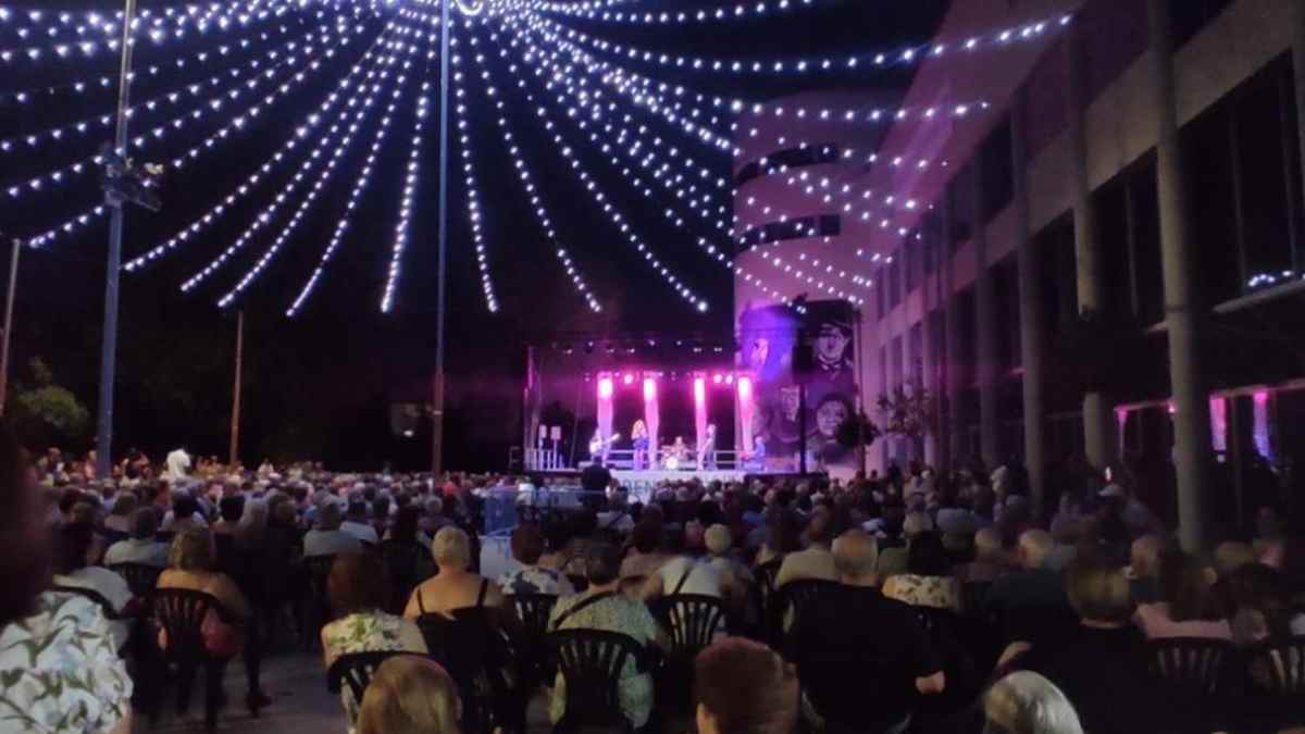 Las Supremas de Móstoles durante su concierto aniversario en la Verbena de verano madrileña, Plaza de la Cultura llena de público nocturno.