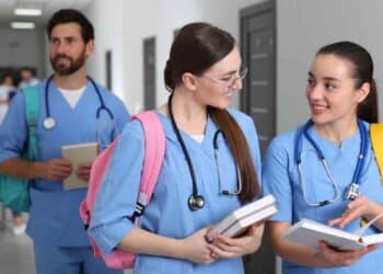 estudiantes MIR y EIR conversan en un pasillo hospitalario tras la oferta de 2.004 plazas en Madrid para 2026.