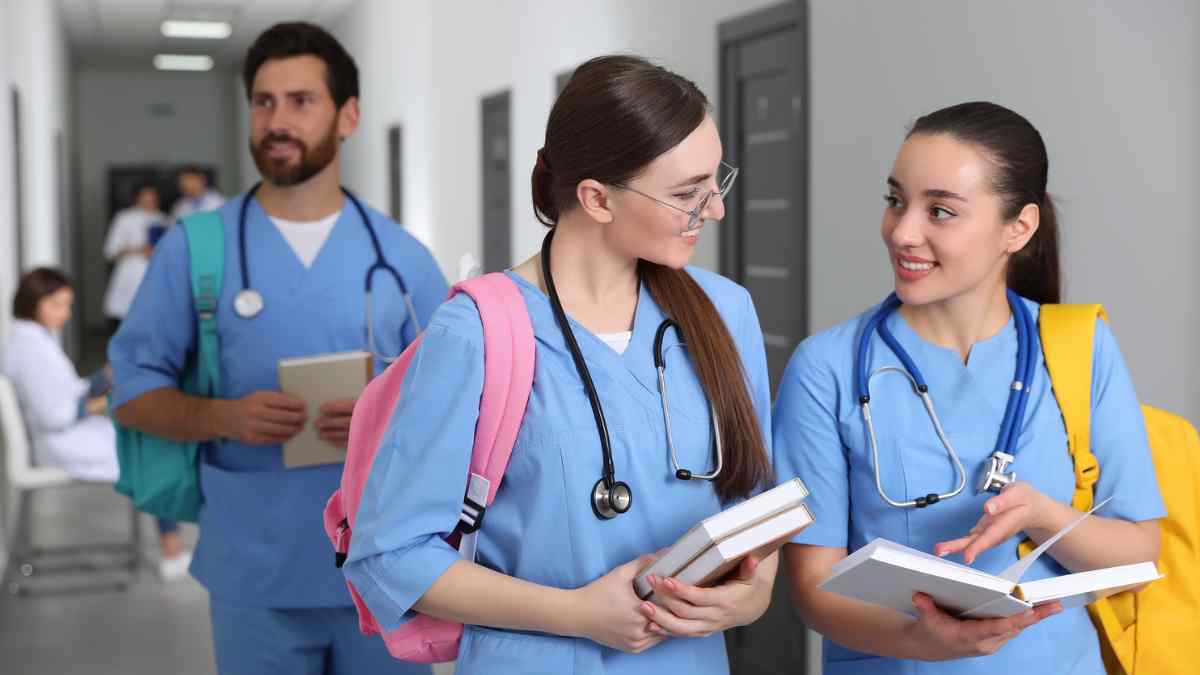 estudiantes MIR y EIR conversan en un pasillo hospitalario tras la oferta de 2.004 plazas en Madrid para 2026.