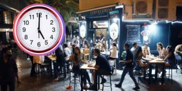 Terraza nocturna de un bar en Madrid llena de clientes, con un reloj marcando la medianoche que ilustra la ampliación de horario de cierre durante el Orgullo 2025.