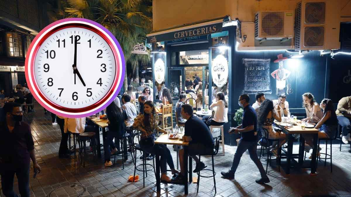 Terraza nocturna de un bar en Madrid llena de clientes, con un reloj marcando la medianoche que ilustra la ampliación de horario de cierre durante el Orgullo 2025.