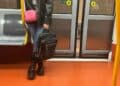 Mujer con mochila en el suelo dentro de un vagón del Metro de Madrid.